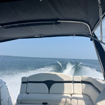View from the rear of a moving boat with a wake in the water.